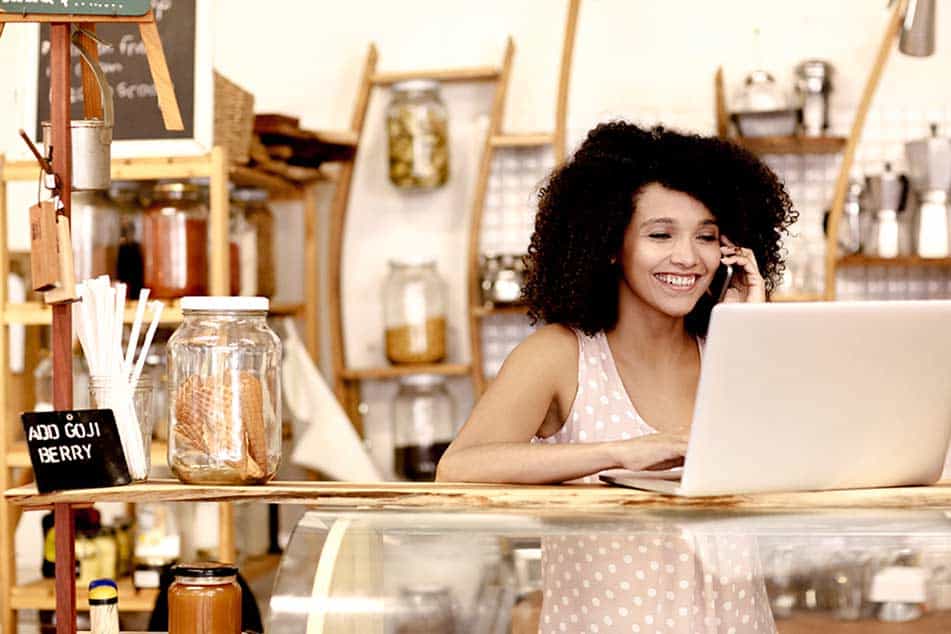 small business owner arranging Public Liability Insurance online, at her cafe