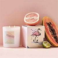 Product photography of Celia Loves candles and fruit props with a pink backdrop