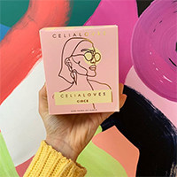 Celia Loves candle in its box with an abstract backdrop