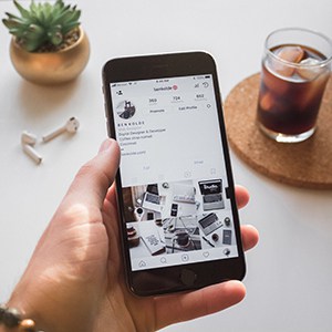 Holding an iPhone 8 with Instagram feed