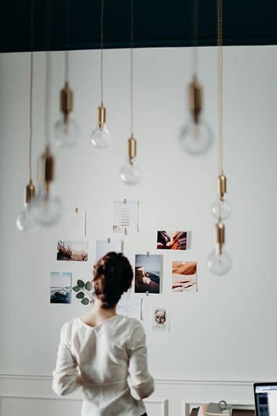 Woman looking at a moodboard pinned on a wall