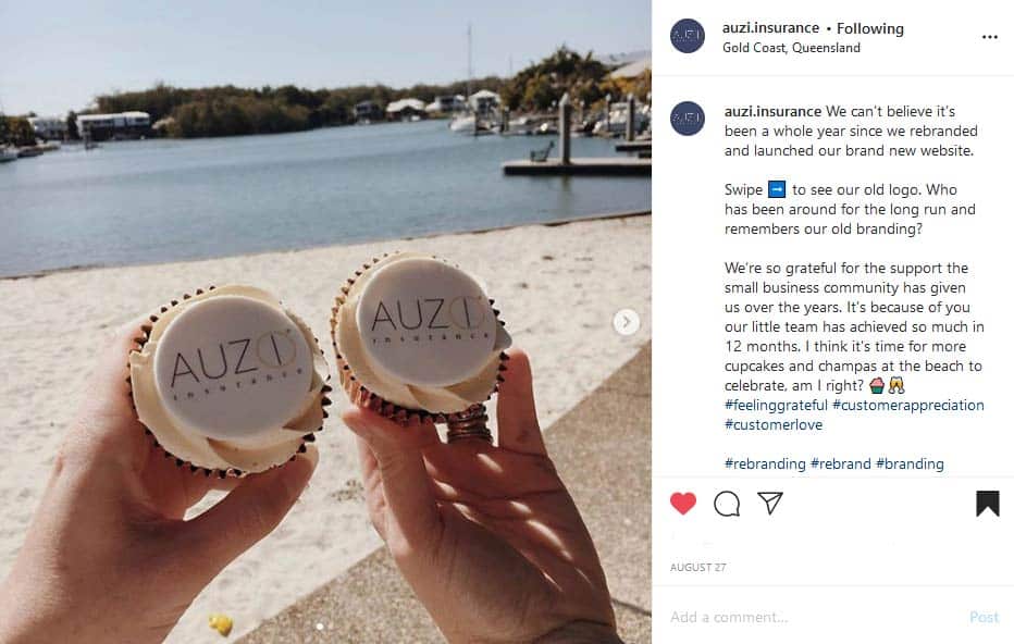 Two white cupcakes with the AUZi Insurance logo on them