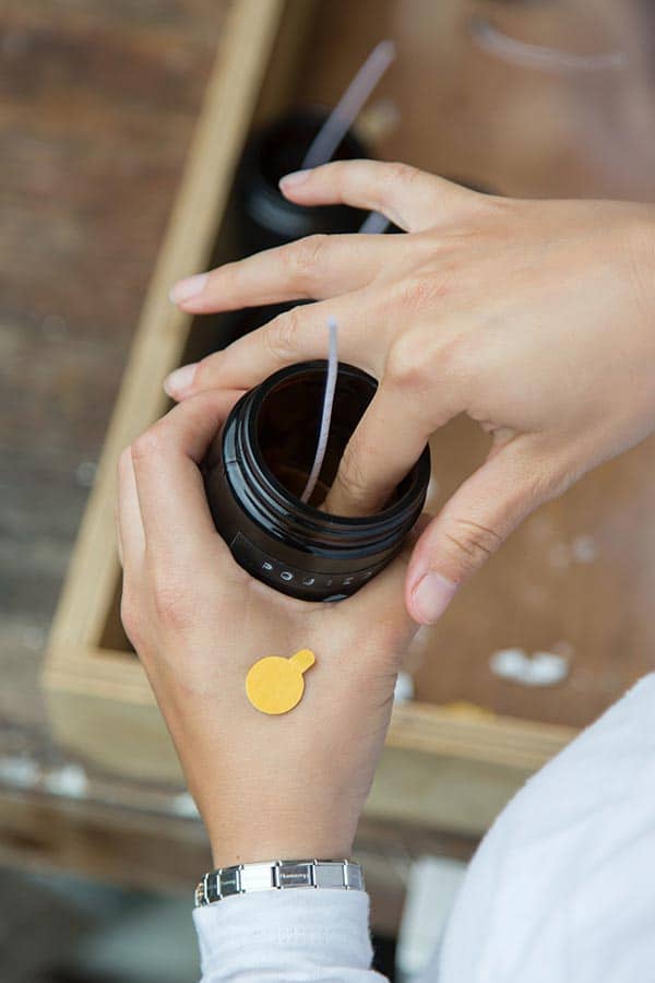 Placing the wick in an amber jar for a candle