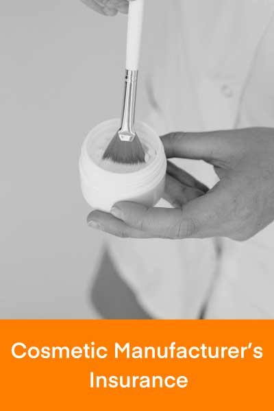 Make up artist dipping a brush in a white cosmetic container