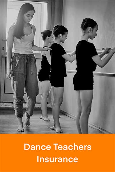 Ballet teacher guides children at the barre in a studio